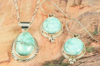 Genuine High Grade Kingman Web Turquoise set in Sterling Silver. Beautiful Pendant and Earrings Set. Created by Navajo Artist Larson Lee. Signed by the artist. The Mineral Park Mine, in the Cerbat Mountains 14 miles northwest of Kingman, was first mined by Indians centuries before white man came to the area. It is one of the three sites of prehistoric mining localities in the state of Arizona. Mineral Park was the most extensively worked area by the Indians of the three. S.A. �Chuck� Colbaugh found a cache of stone hammers uncovered in ancient trenches and tunnels, when he had the turquoise mining concession in May of 1962. Ithaca Peak and Turquoise Mine (formally called Aztec Mountain or Aztec Peak) are the most famous of the peaks in the area containing turquoise.